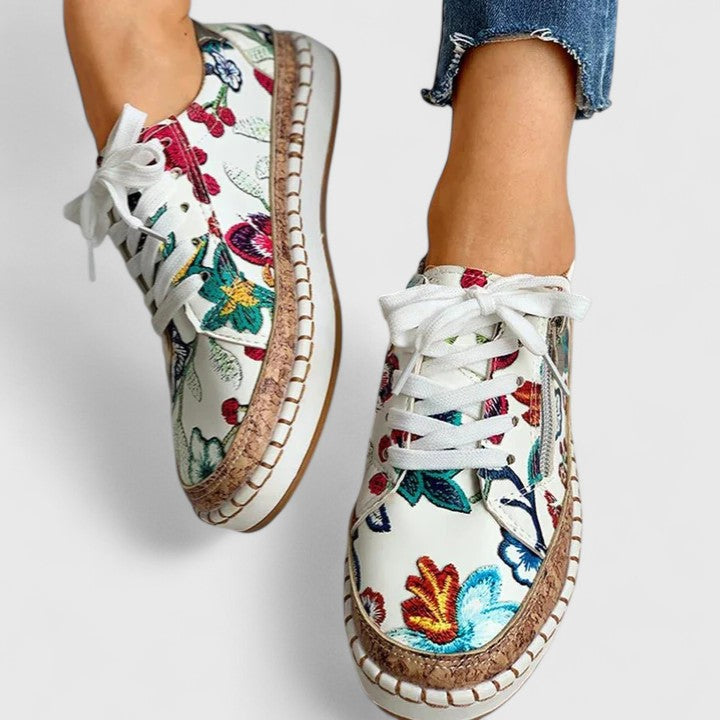 Sneakers da donna con stampa floreale, suola platform e allacciatura.