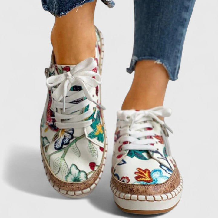 Sneakers da donna con stampa floreale, suola platform e allacciatura.